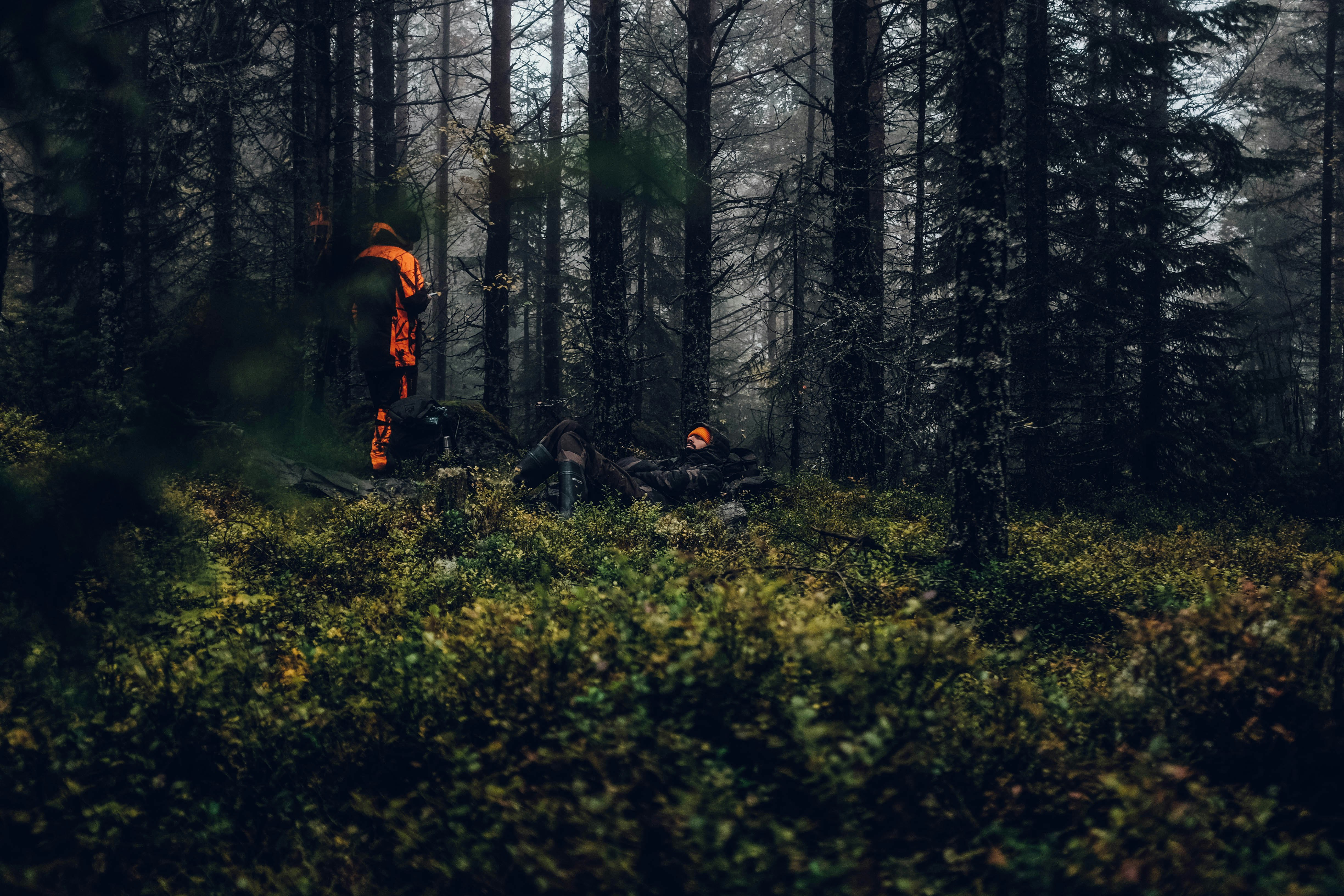 man standing on forest while doing bonfire